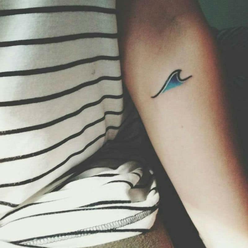 Minimalist wave tattoo on the back of the right arm