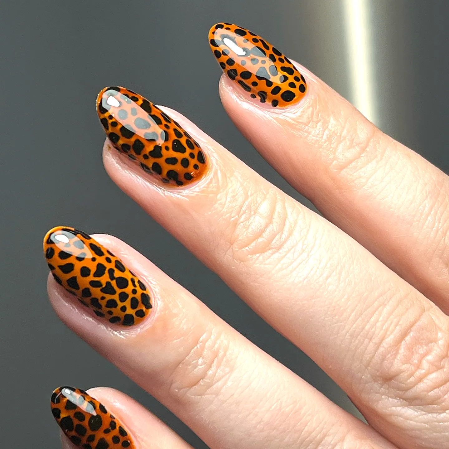 Bold Almond Shaped Animal Print Nails in Glossy Orange with Chic Black Leopard Spots
