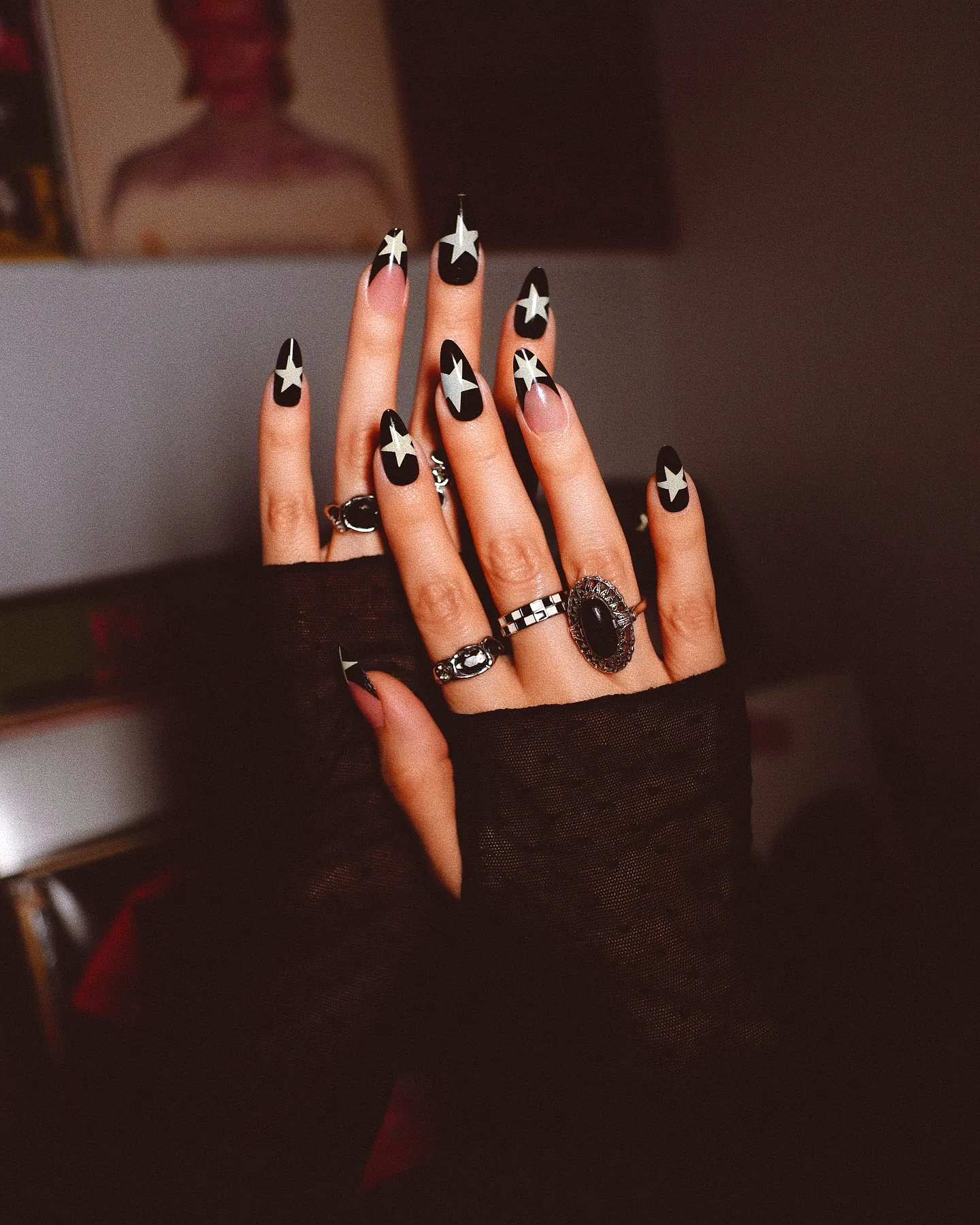 Bold stiletto fall ombre nails with glossy black base and vibrant green star patterns
