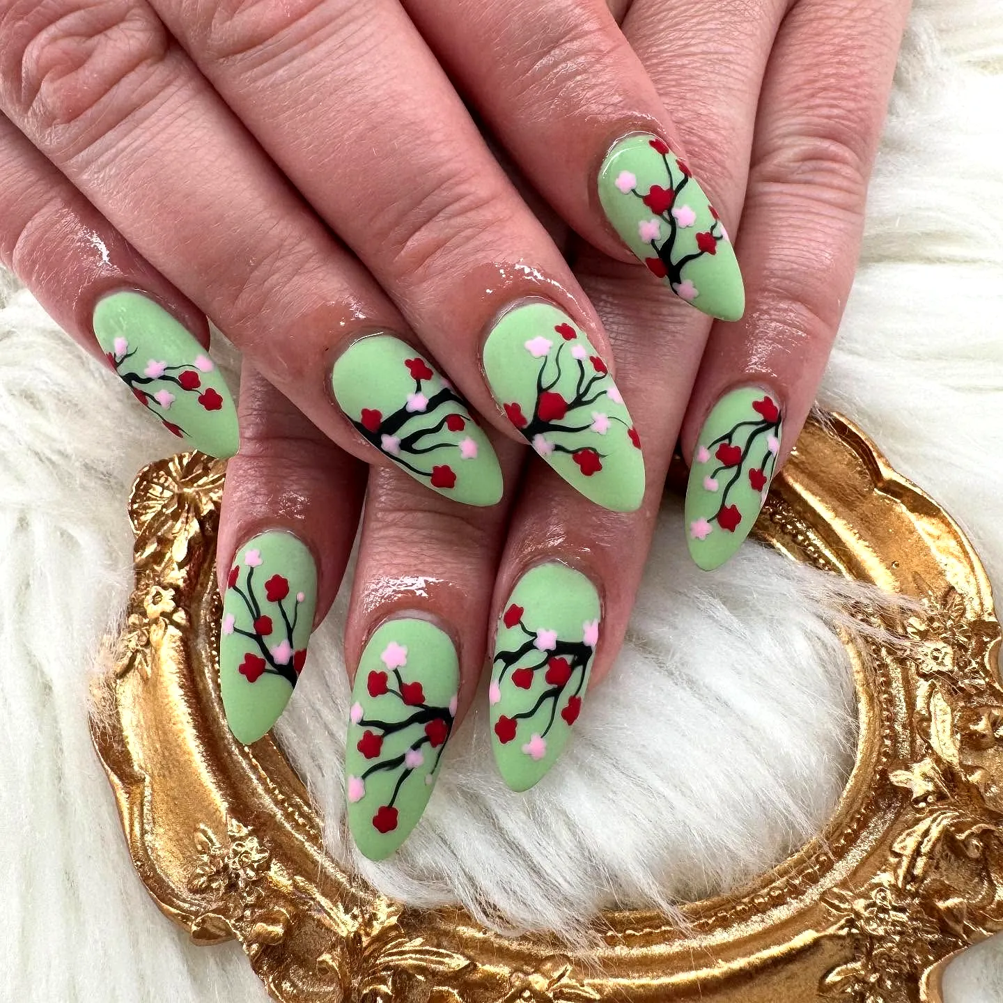 Charming Almond-Shaped Cherry Blossom Nails in Soft Green with Intricate Floral Art