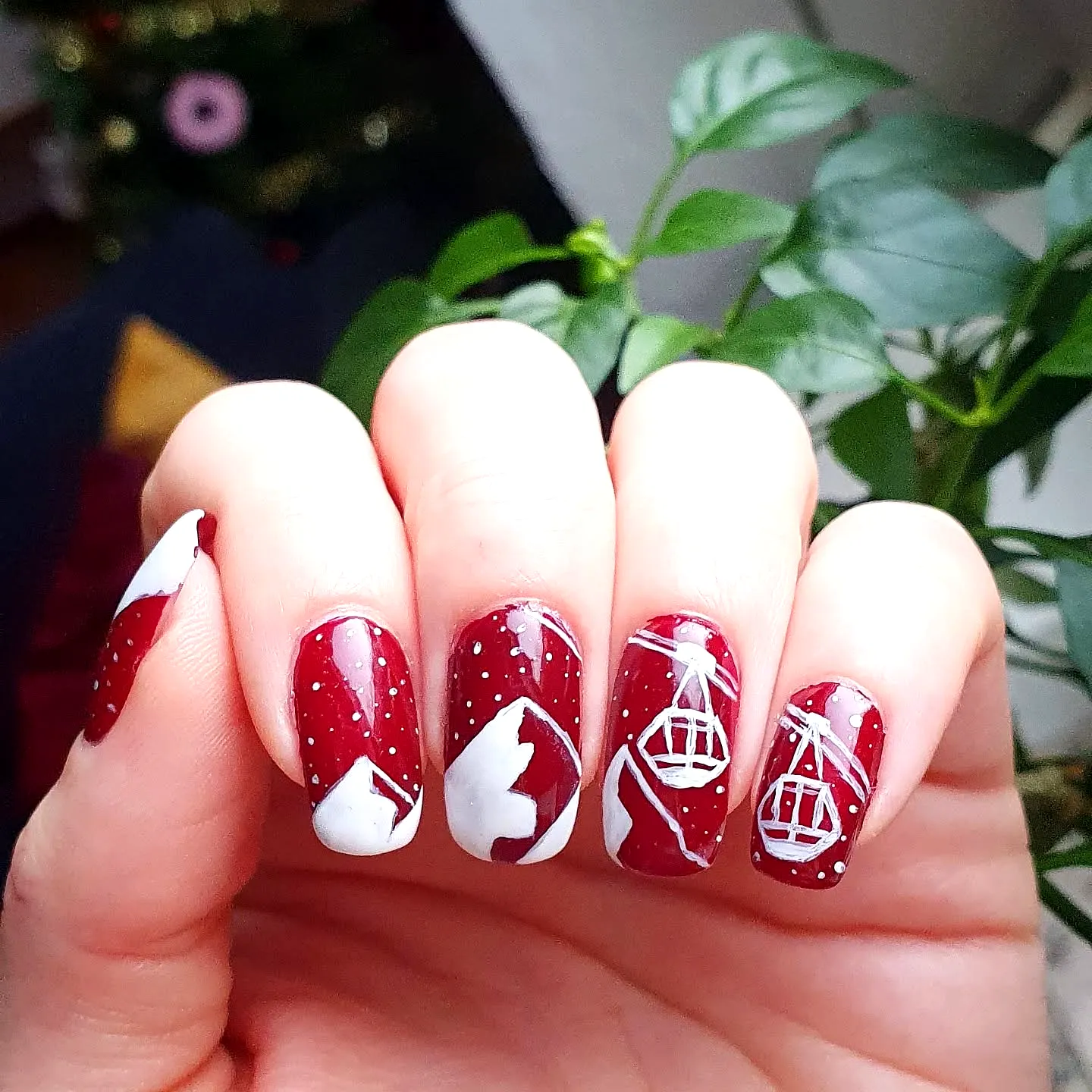 Charming Almond Shaped Mountain Nails with Glossy Deep Red Base White Geometric Shapes and Festive Winter Motifs