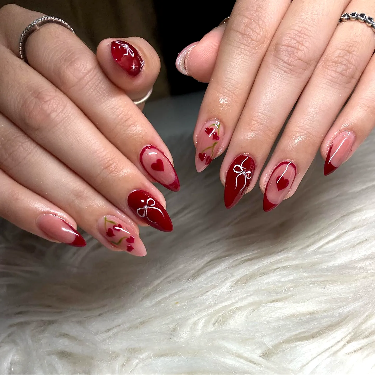 Charming Almond-Shaped Red Nails with Heart Patterns Floral Accents and Ribbons