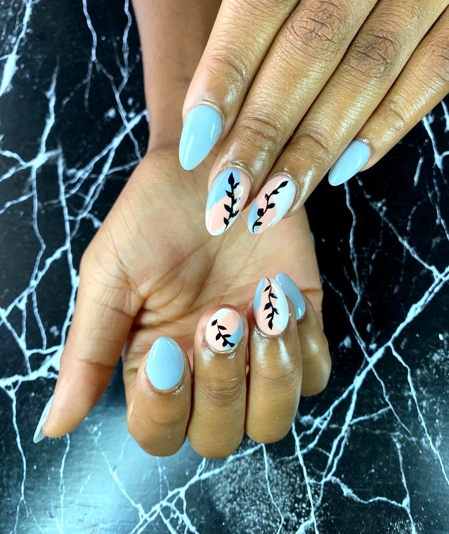 Chic Almond and Oval Leaf Nail Designs in Soft Gray with Peach Accents and Delicate Black Patterns