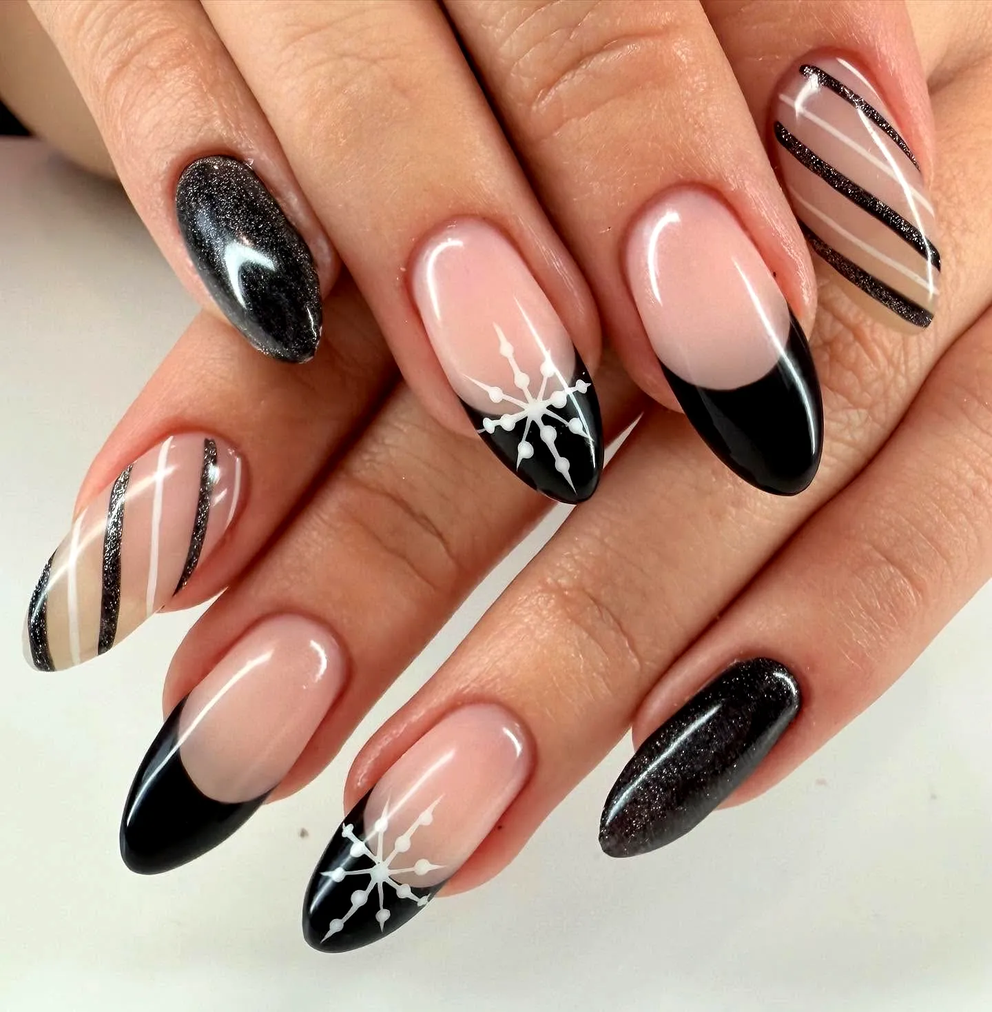 Chic Almond-Shaped Black Nails with Glitter Accents and Intricate Patterns