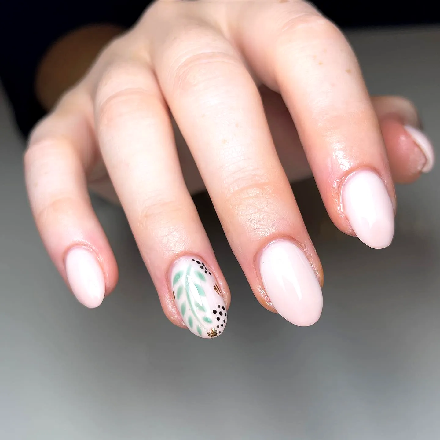 Chic Almond Shaped Honeymoon Nails in Nude with Delicate Green Leaf Art