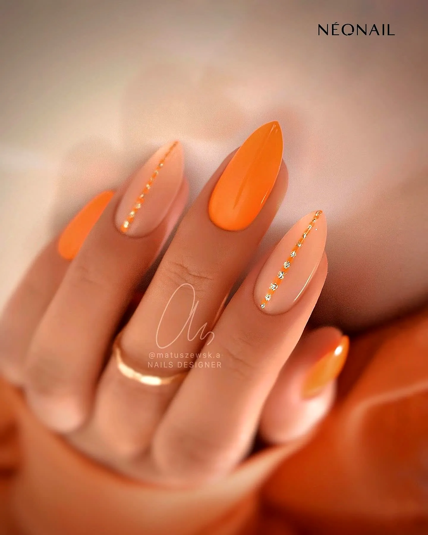 Chic Almond Shaped Orange Nails with Gold Rhinestone Accents