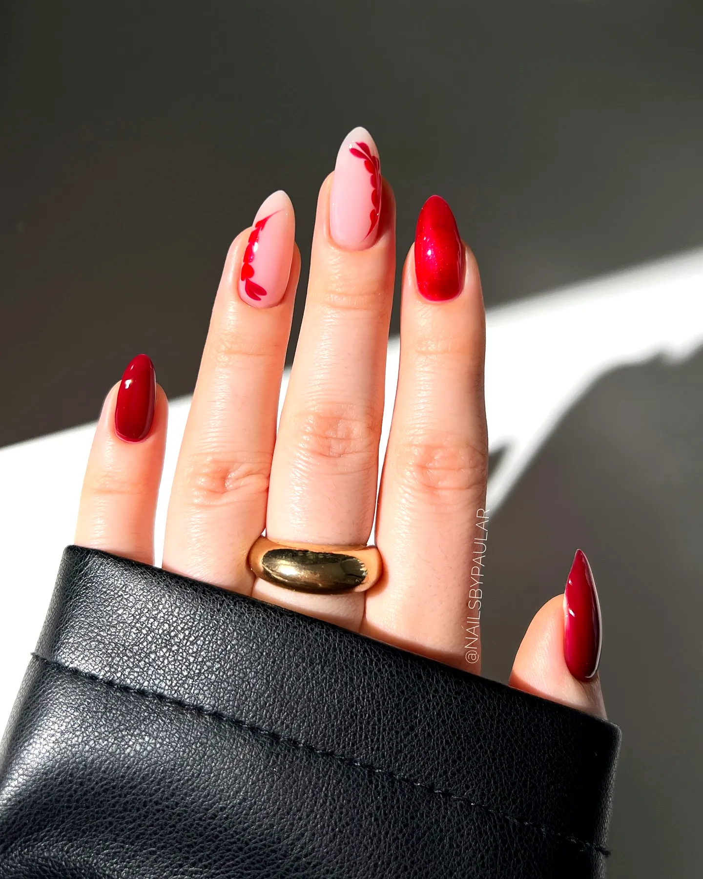 Chic Almond Shaped Red Nails with Floral Accents and Glitter Finish