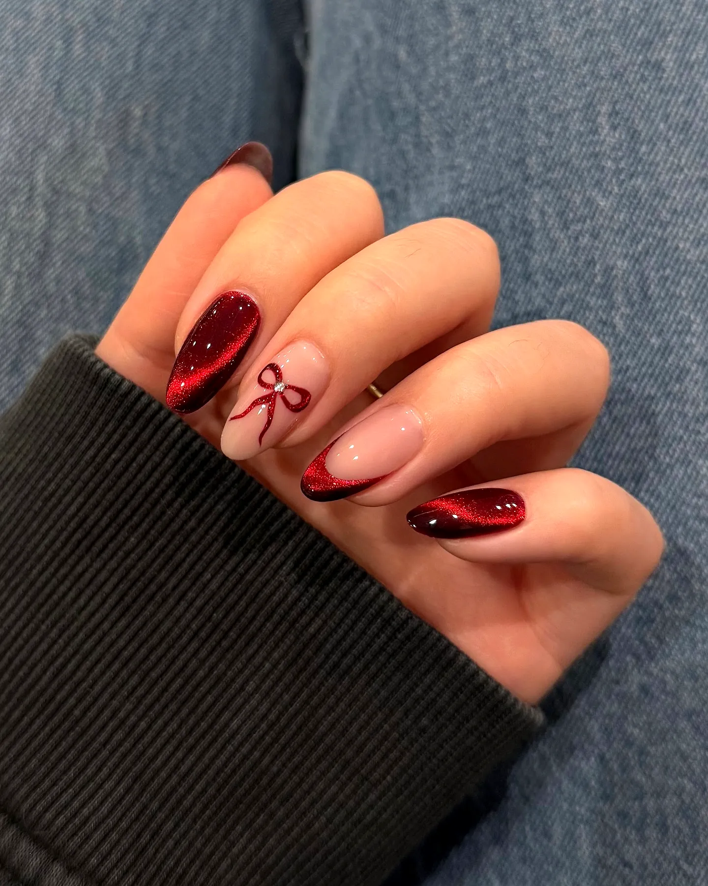 Chic Almond-Shaped Red Nails with Glittering Burgundy and a Cute Bow