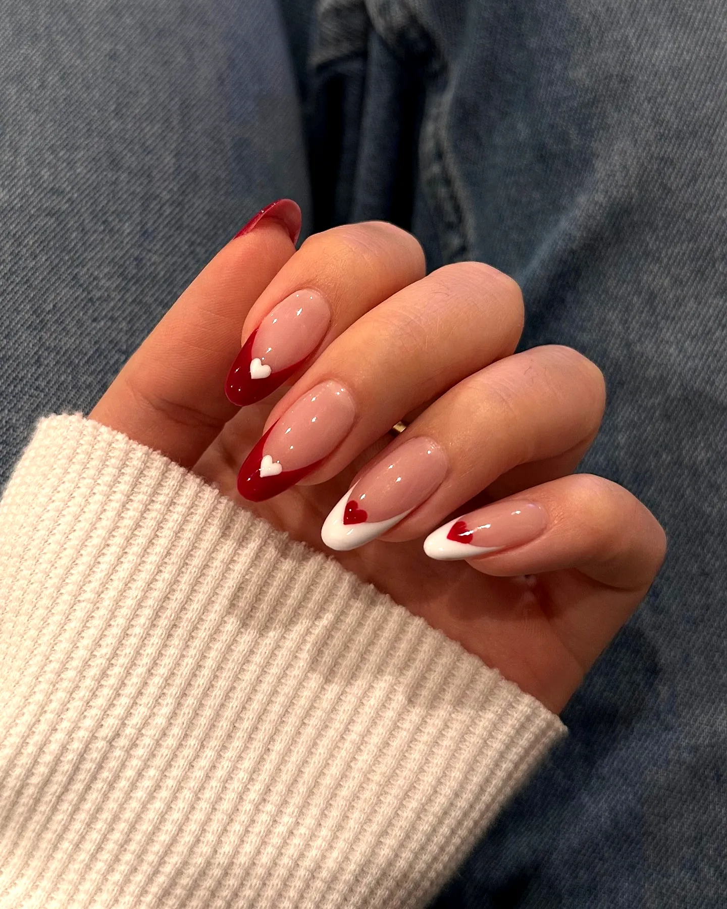 Chic Almond Shaped Red Nails with Playful French Tips and Heart Accents