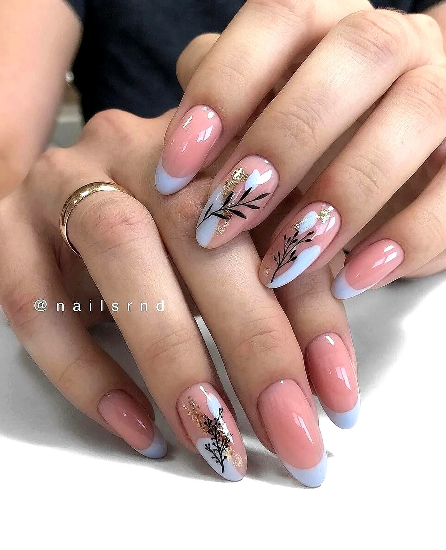 Chic Almond Shaped Summer Nail Designs with Nude Pink Base Light Blue Tips and Elegant Floral Patterns in Black and Gold