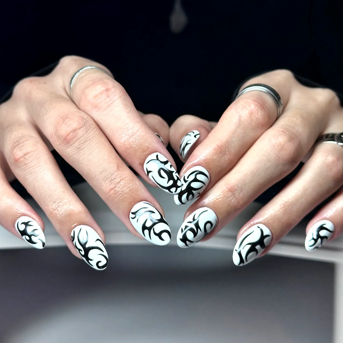 Chic Almond Shaped Tribal Nails in White with Intricate Black Floral Patterns