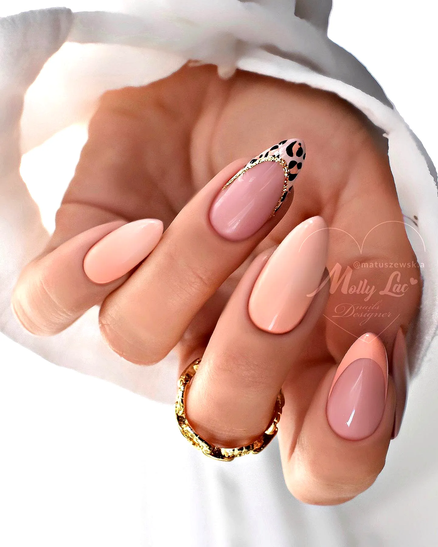 Chic almond shaped tropical nail designs with glossy nude and pink shades featuring leopard print accents and gold embellishments
