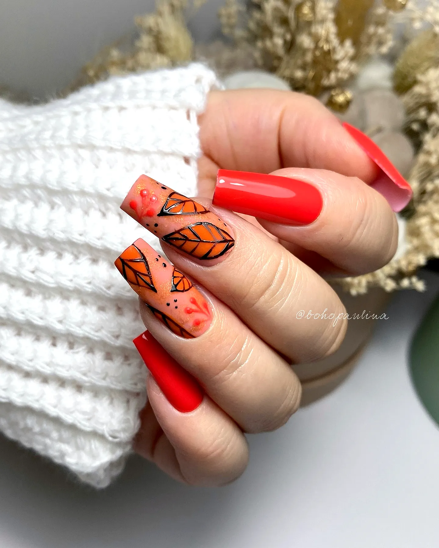 Chic coffin orange nails with autumn leaf nail art and glossy red accents