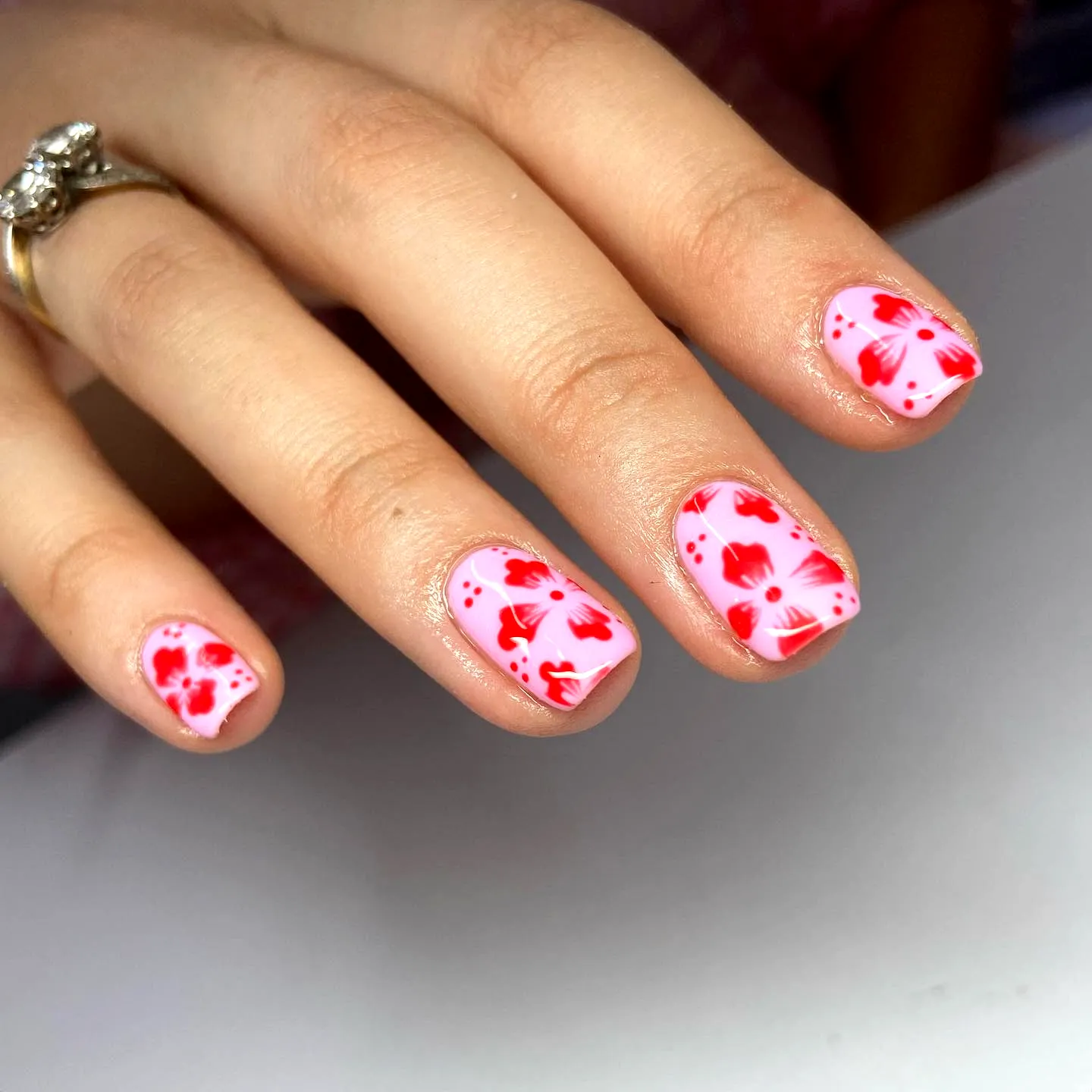 Chic Oval Honeymoon Nails with Soft Pink Base and Vibrant Red Floral Art