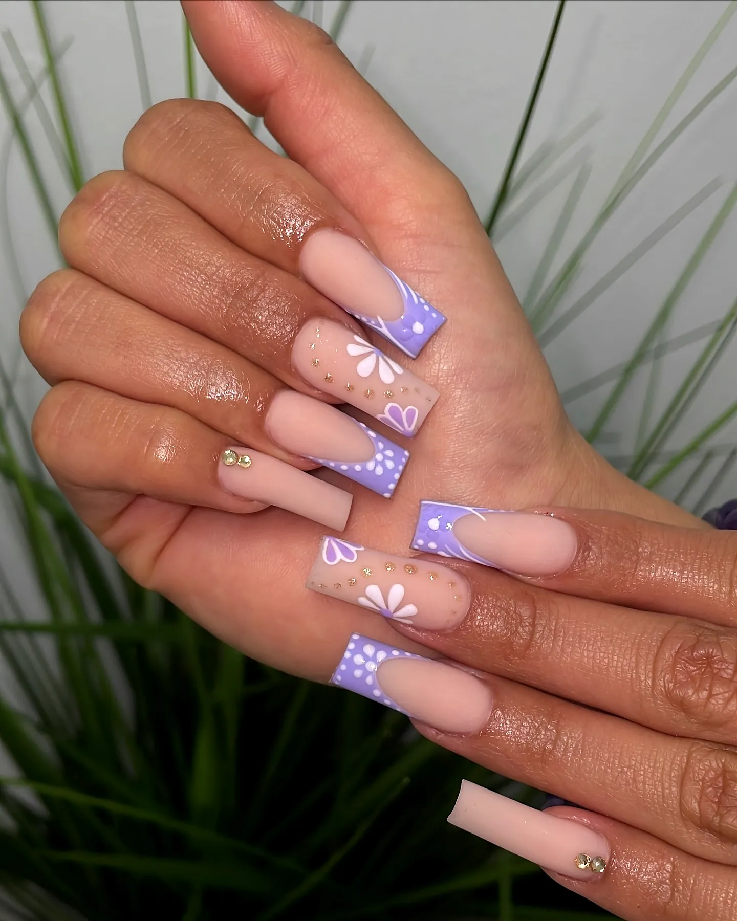 Chic pastel lavender long square purple spring nails with floral patterns and gold studs