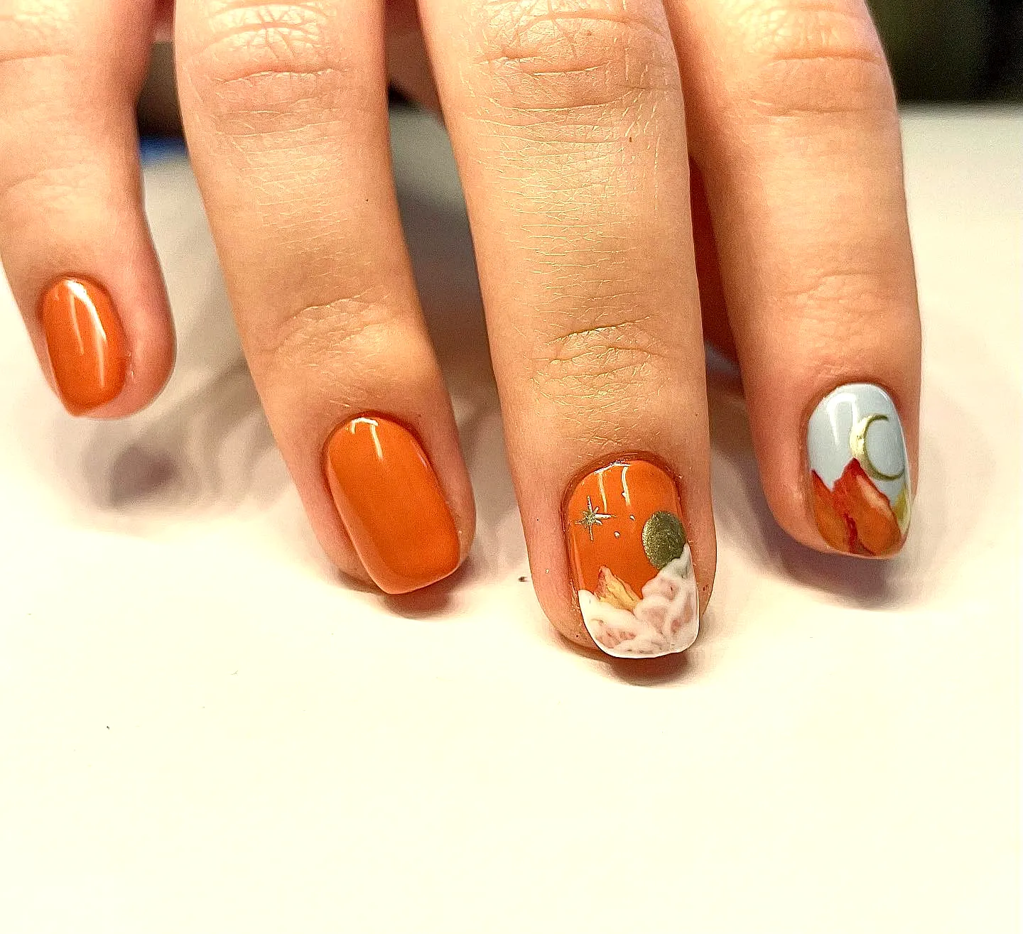 Chic Round Mountain Nails with Warm Orange and Pastel Floral and Celestial Designs
