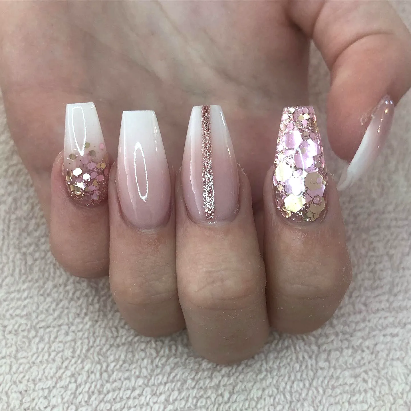 Cute almond and squared rose gold nails with glossy ombre and glittery accents