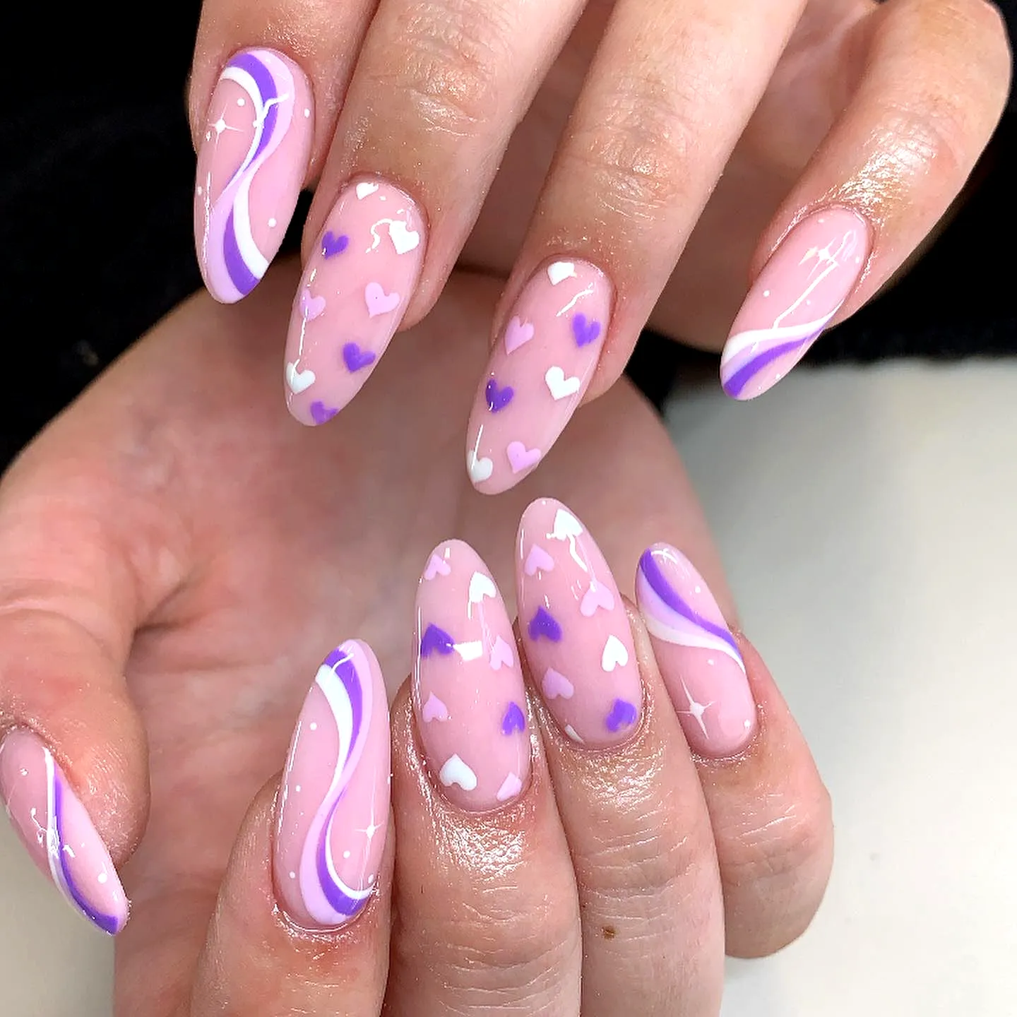 Cute Almond Purple Nails with Abstract Swirls and Heart Patterns in Trendy Nail Art Style