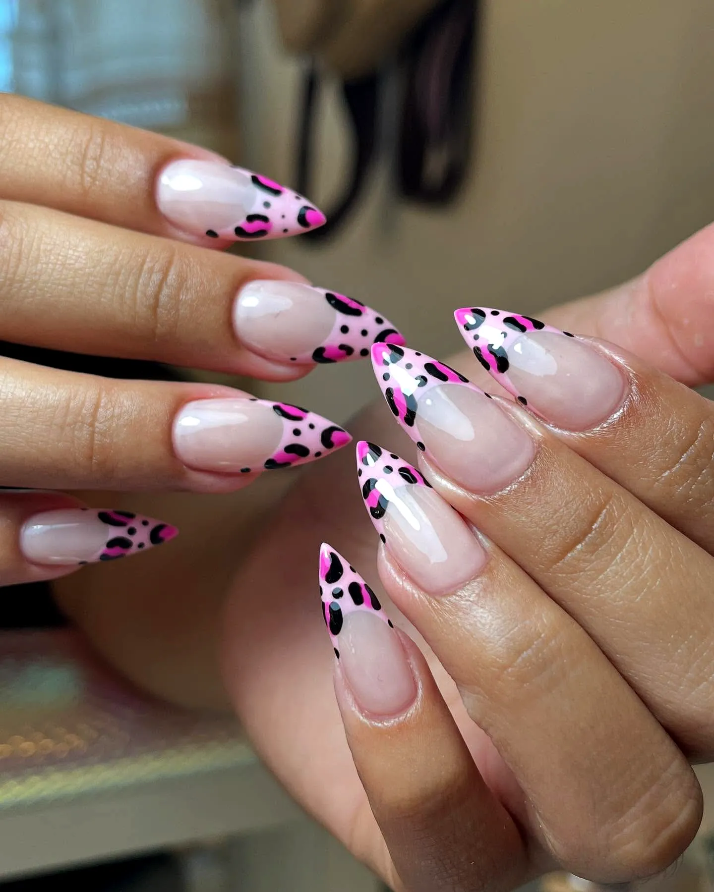 Cute almond-shaped animal print nails with vibrant pink tips and black leopard spots
