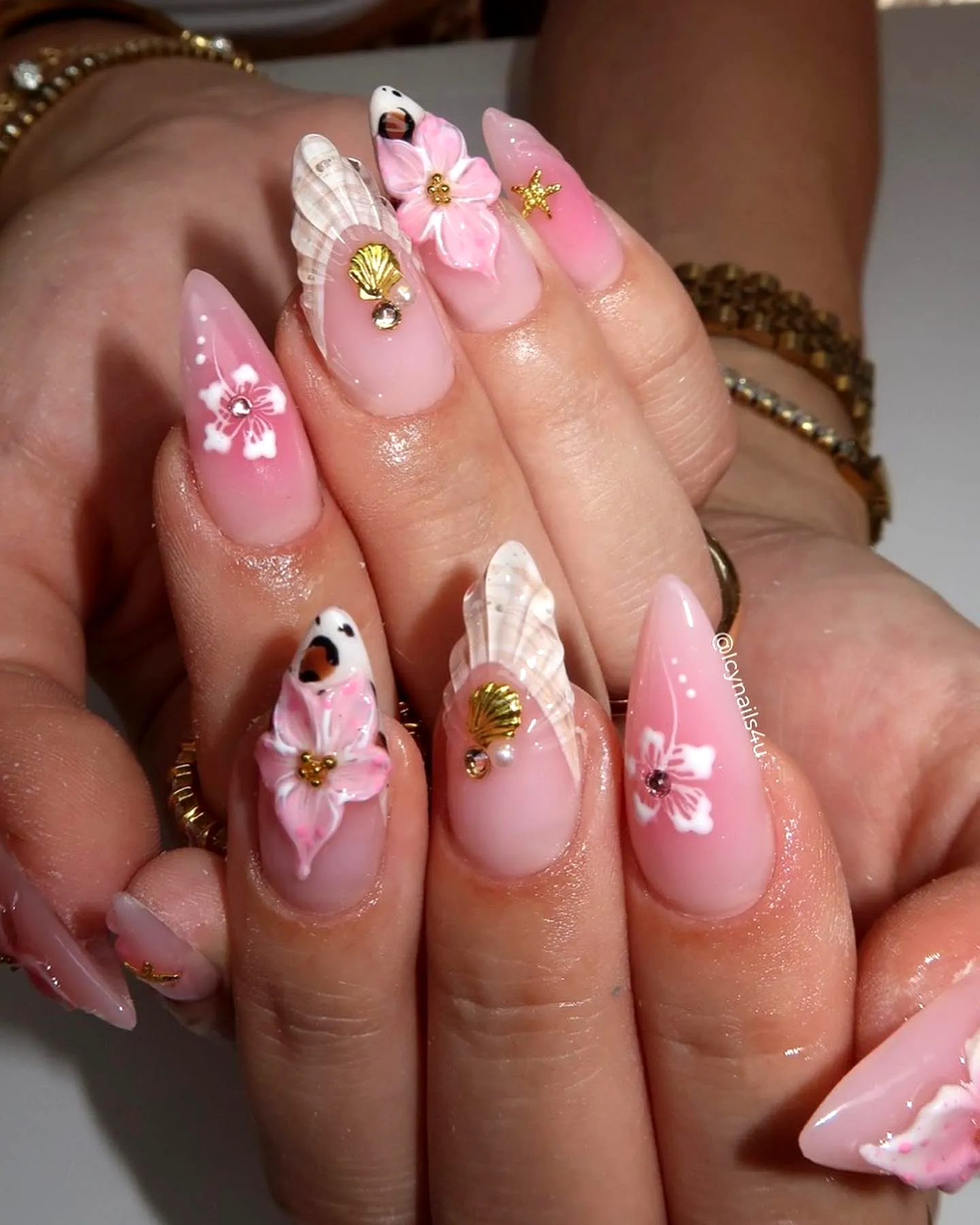Cute Almond Shaped Beach Nails in Soft Pink with Floral Patterns Seashell Embellishments and Gold Accents