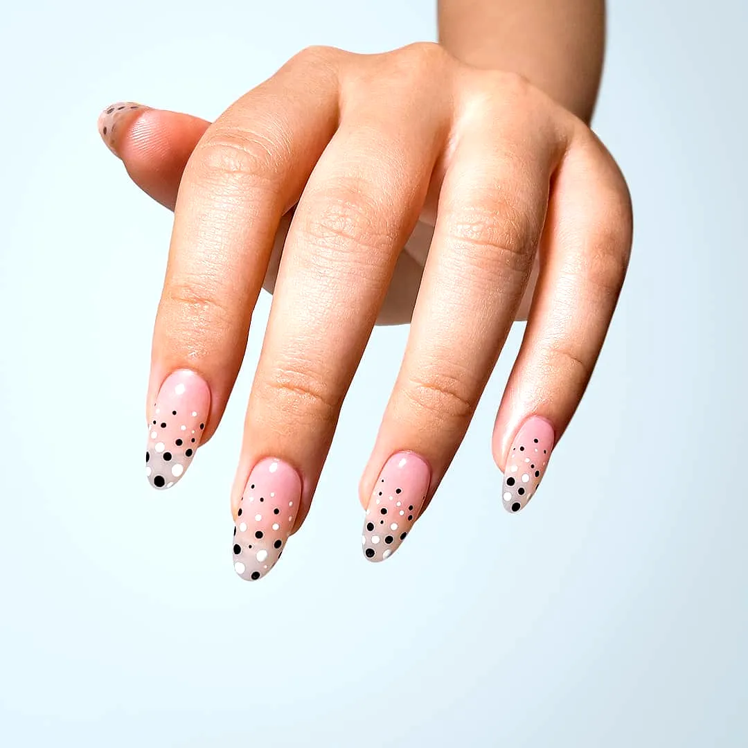 Cute almond shaped black and white polka dot nails with a soft pink gradient