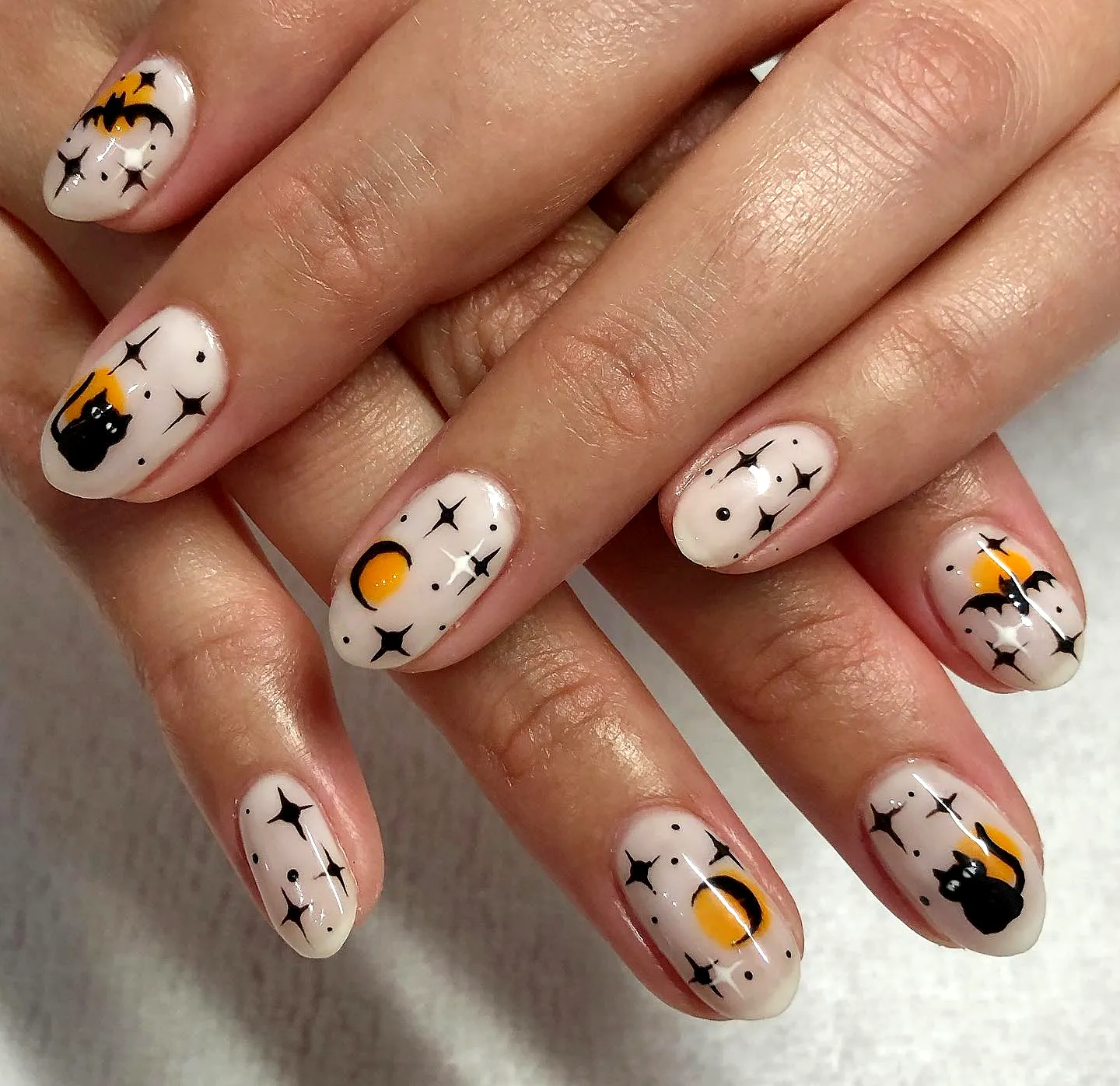 Cute Almond-Shaped Black Cat Nails with Whimsical Halloween Elements in Beige and Orange