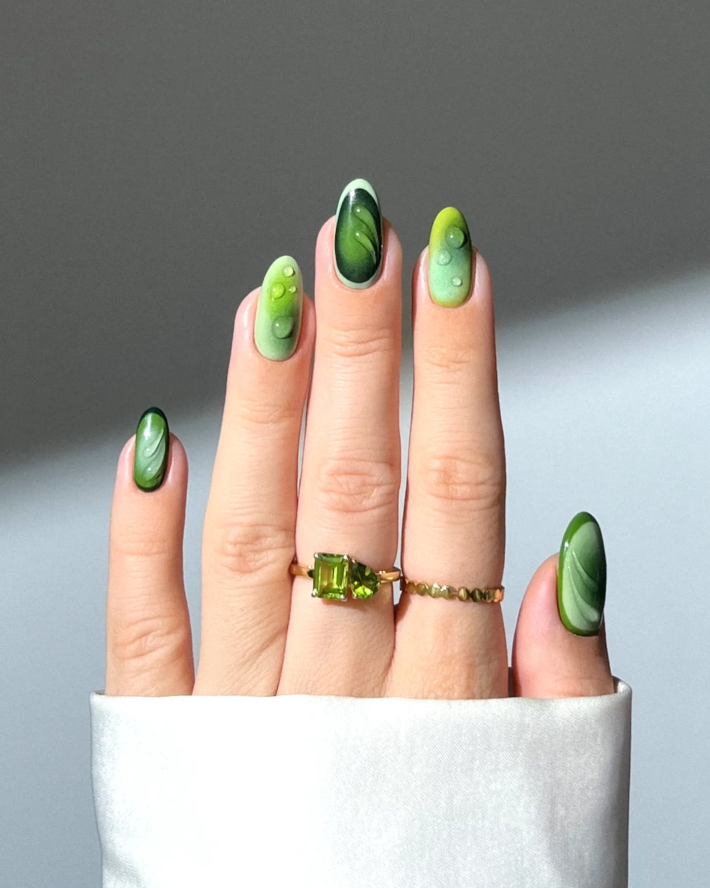 Cute almond shaped fall ombre nails with vibrant green marble patterns and glossy finishes