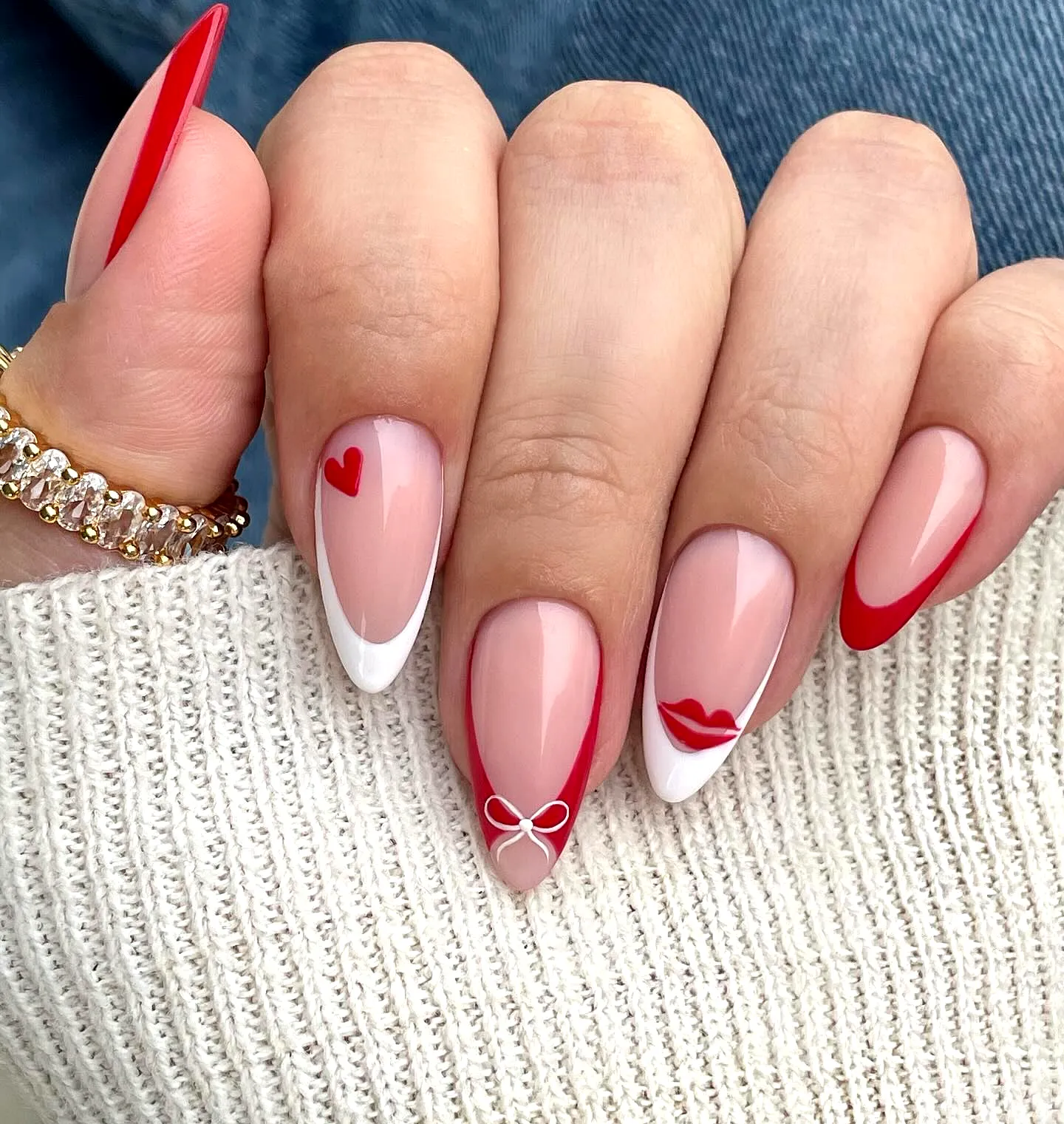 Cute almond-shaped French heart nails with red and white accents and playful motifs