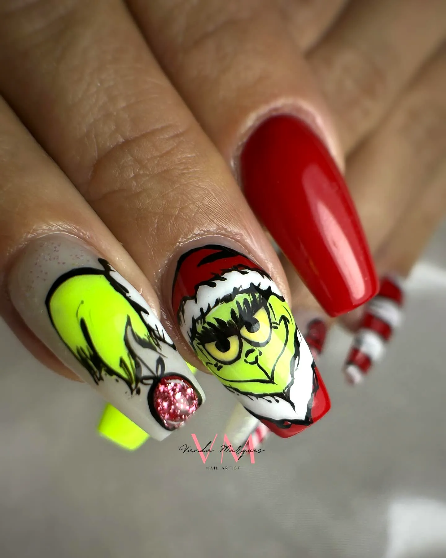 Cute almond-shaped Grinch nails in vibrant red and neon green with playful holiday art elements