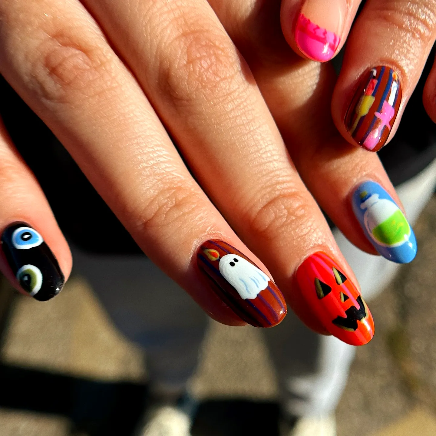 Cute almond-shaped Halloween nails for kids with bold colors and playful ghost jack-o-lantern and eyeball designs
