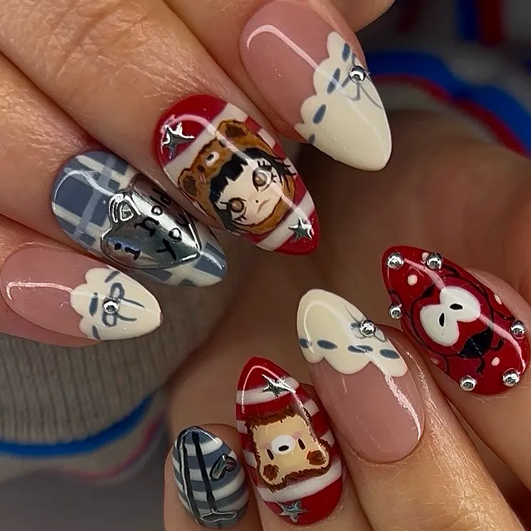 Cute almond-shaped Halloween nails for kids with playful cartoon characters and whimsical embellishments in red beige grey and white