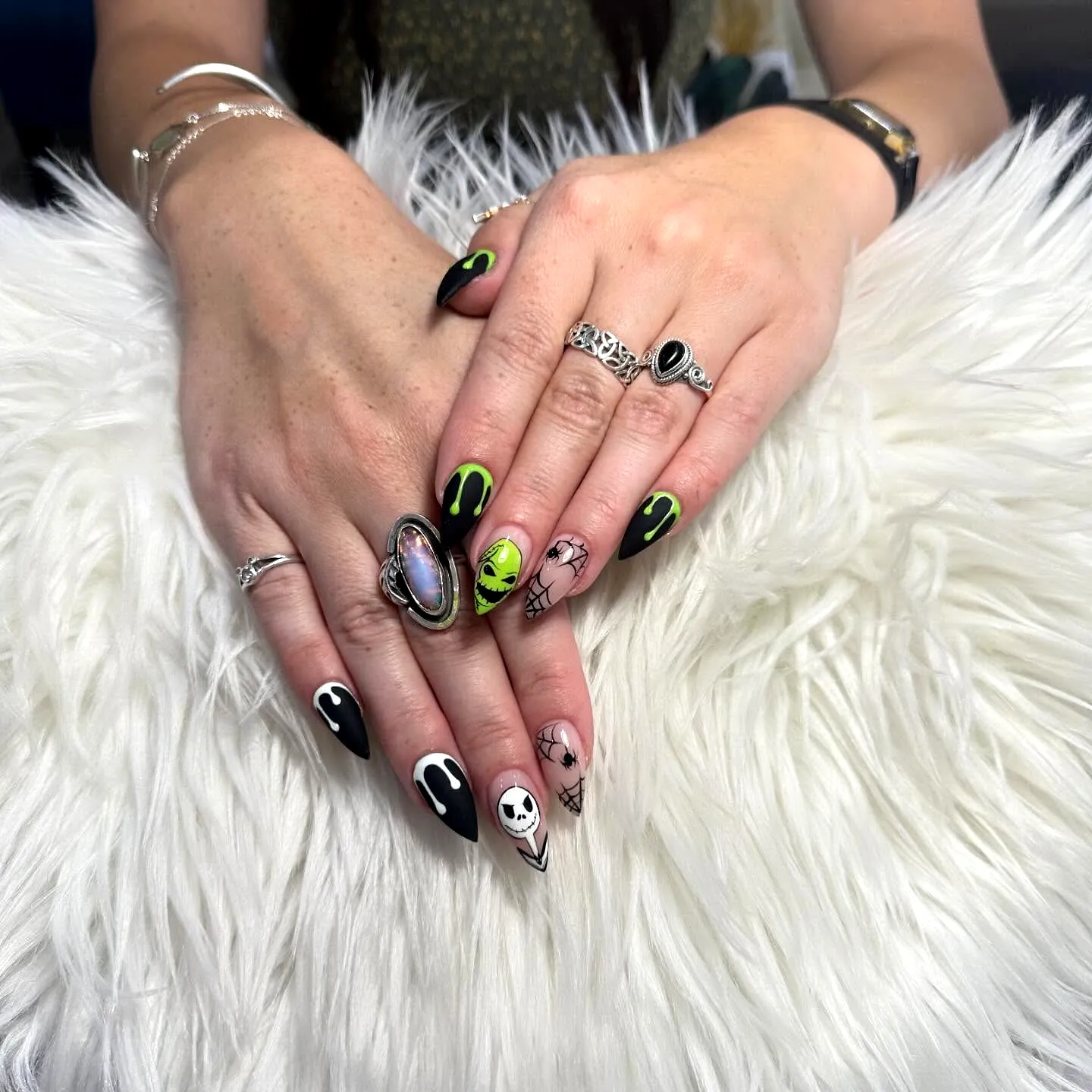 Cute almond shaped Nightmare before christmas nails with bold black and vibrant green colors featuring alien and skull motifs