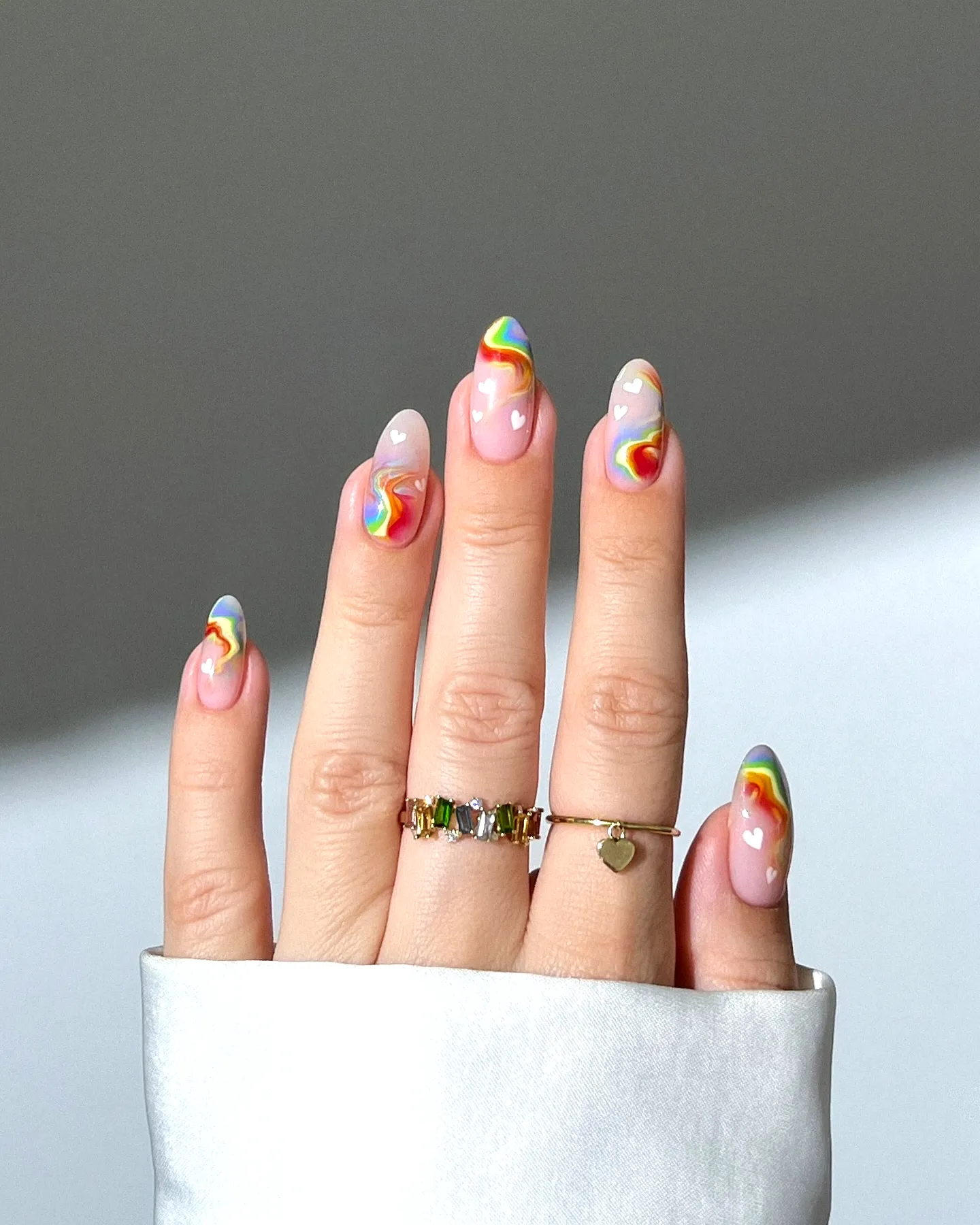 Cute almond-shaped summer nail designs with soft pink base rainbow stripes and heart patterns