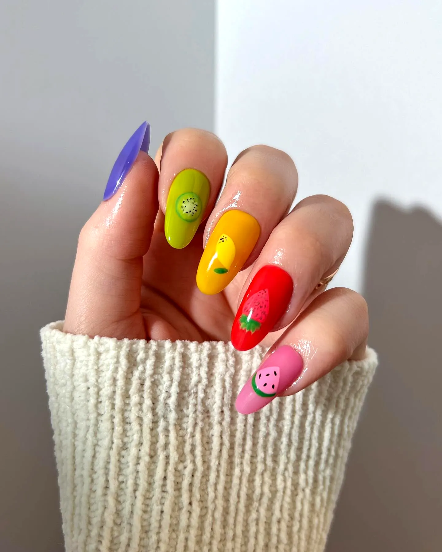 Cute almond-shaped summer nail designs with vibrant fruity motifs and bold patterns