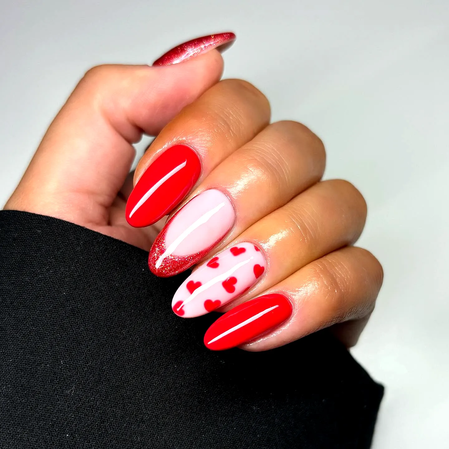 Cute and Romantic Valentines Day Nails in Almond and Stiletto Shapes with Glitter and Heart Accents