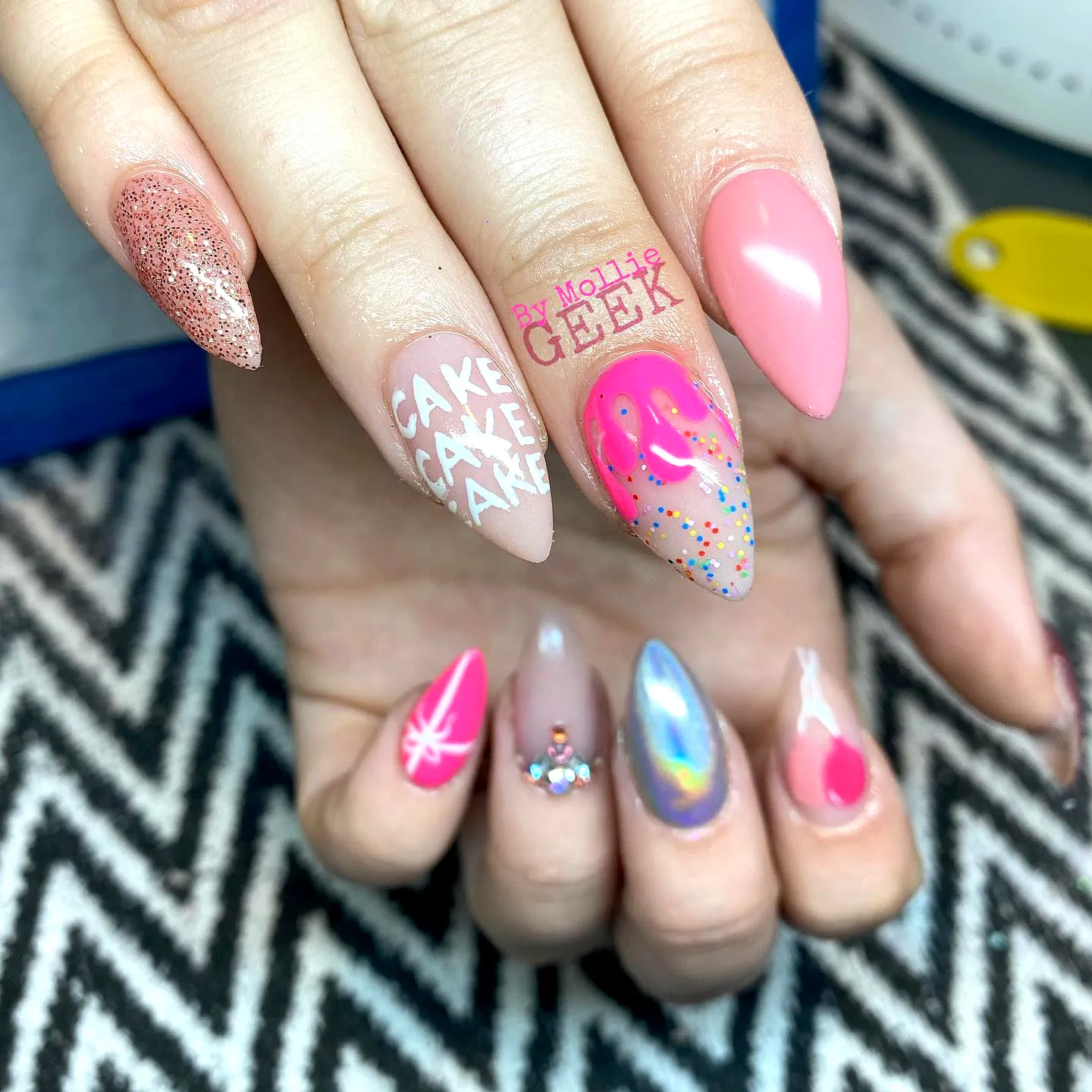 Cute Birthday Cake Nails with Pointy and Rounded Tips in Pink Glitter and Pastel Shades Featuring Whimsical Cake Artwork and Sprinkles