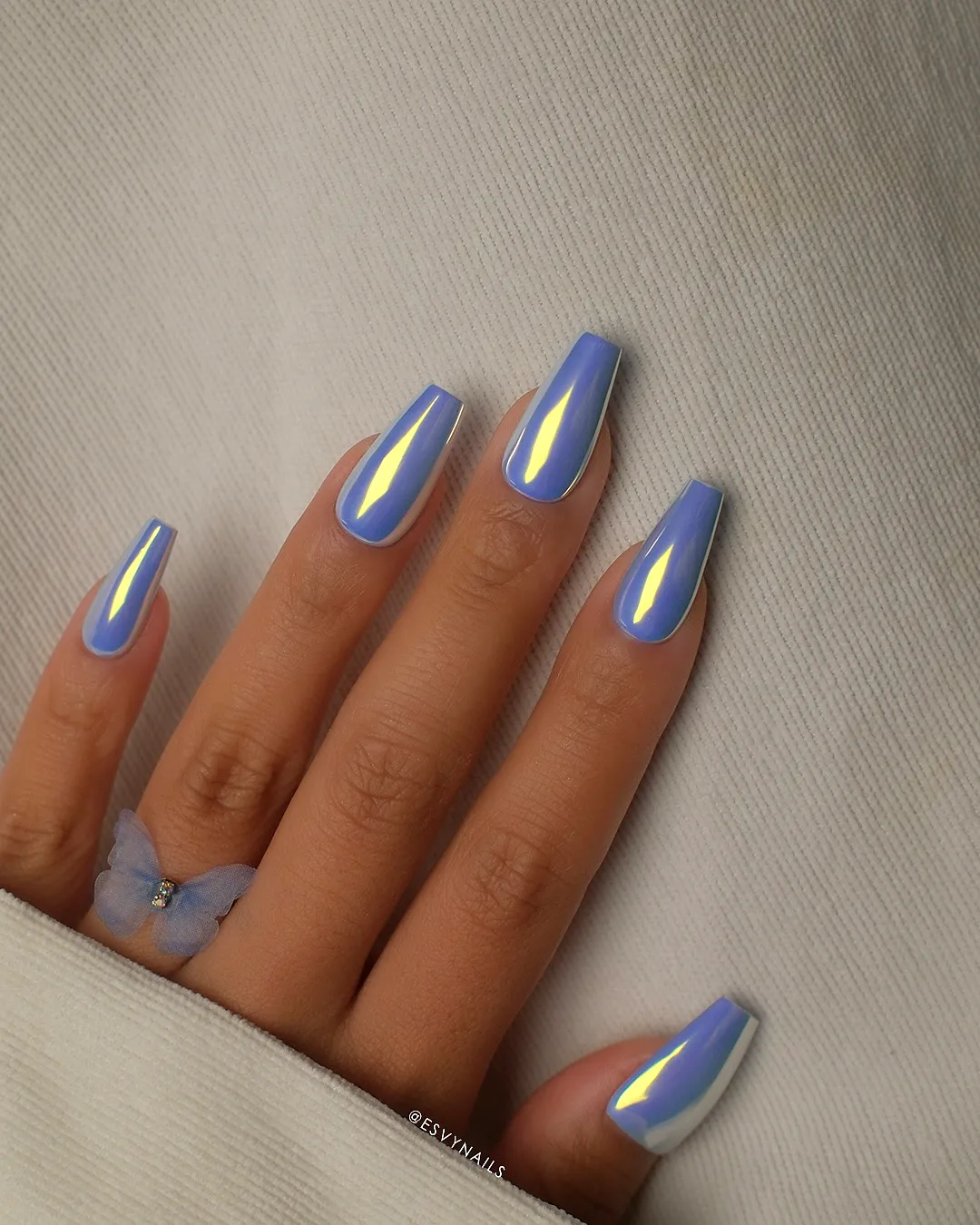 Cute elongated coffin-shaped chrome nails in soft blue with butterfly art and glossy shimmer