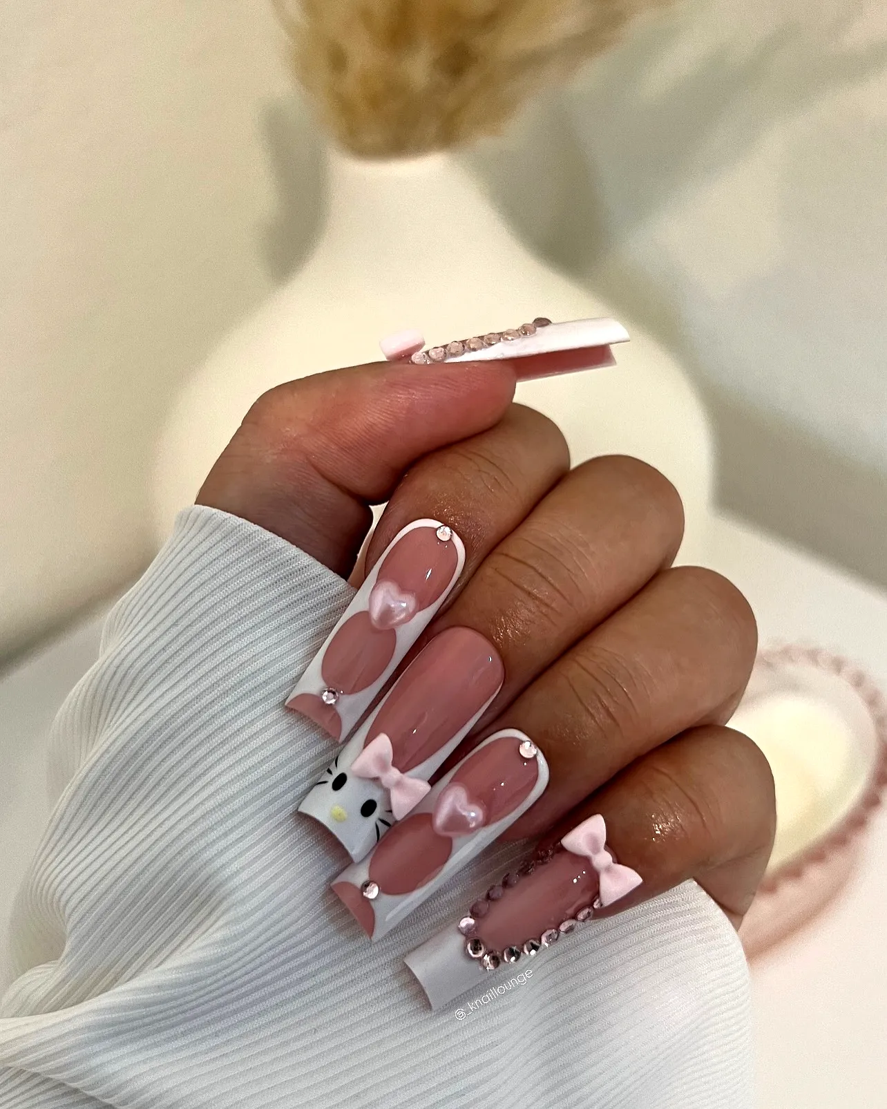 Cute elongated square pink birthday nails with whimsical decorations and glossy finishes