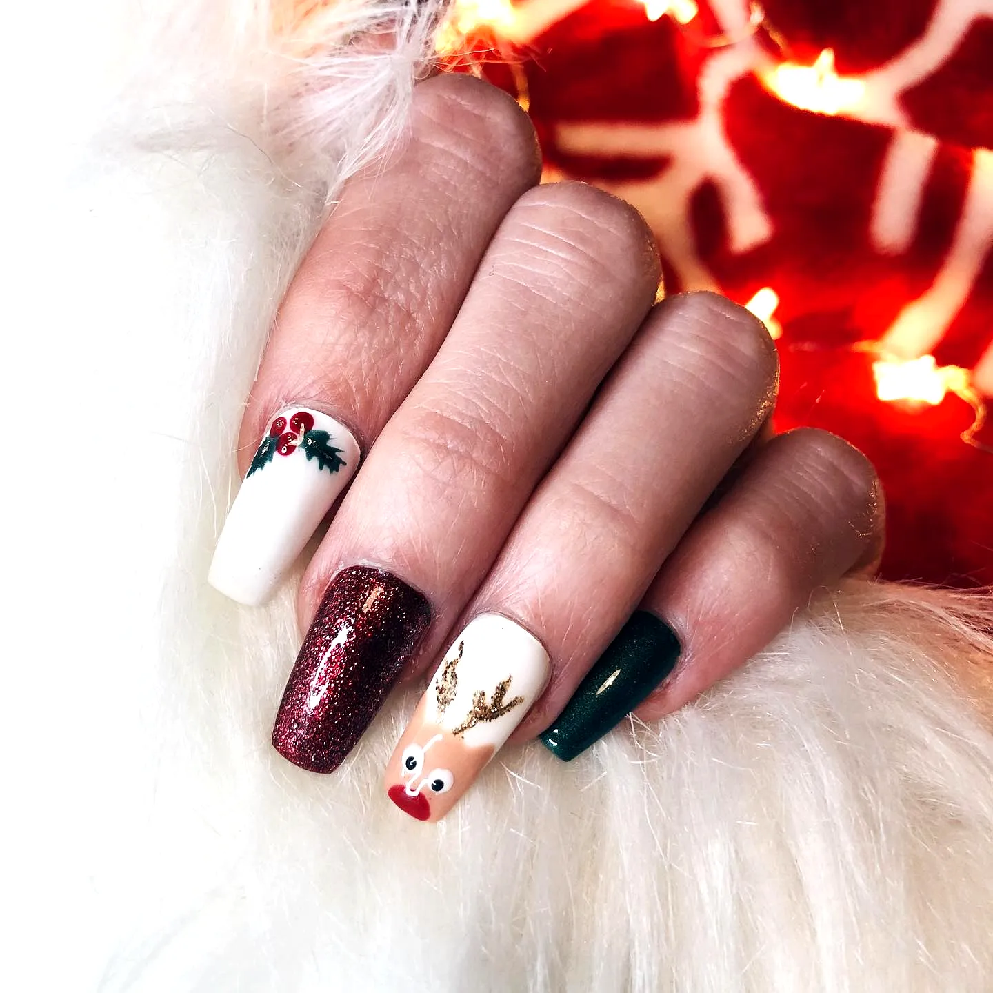 Cute festive reindeer nail designs with square and almond shapes in red green and white featuring glitter accent and holly decorations