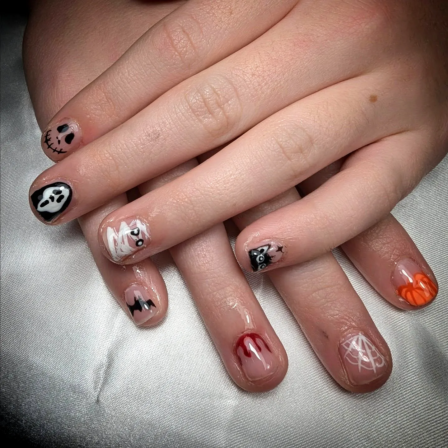 Cute Halloween Nails for Kids with Rounded and Almond Shapes Featuring Colorful Skull Ghost Pumpkin and Dripping Blood Designs