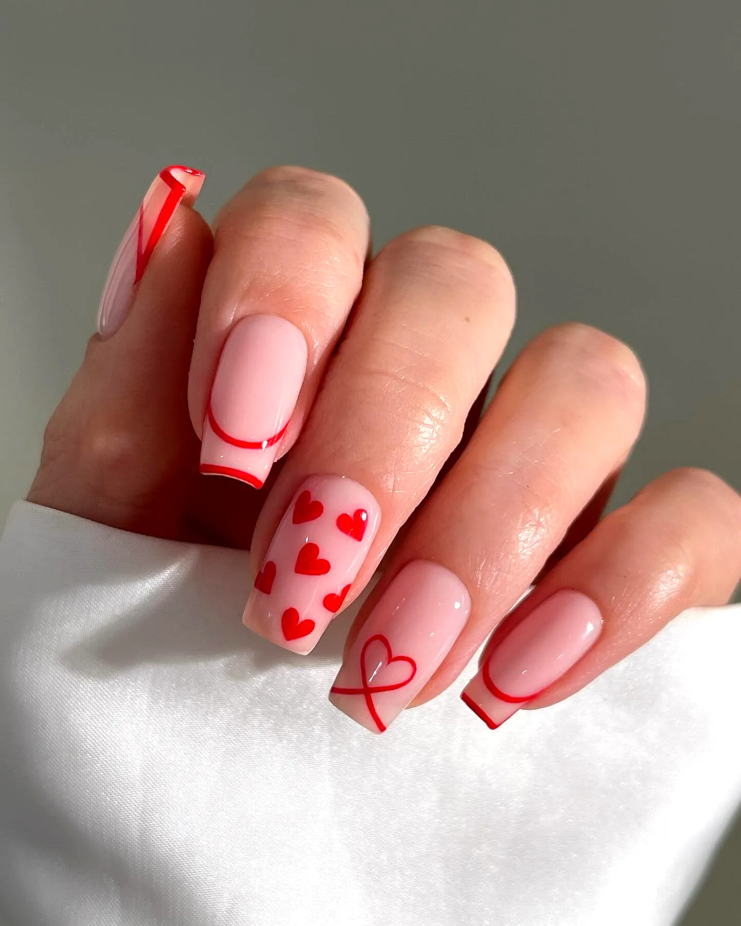 Cute Minimalistic Valentines Day Nails with Soft Pink Base Red Heart Patterns and Trendy Square Shape