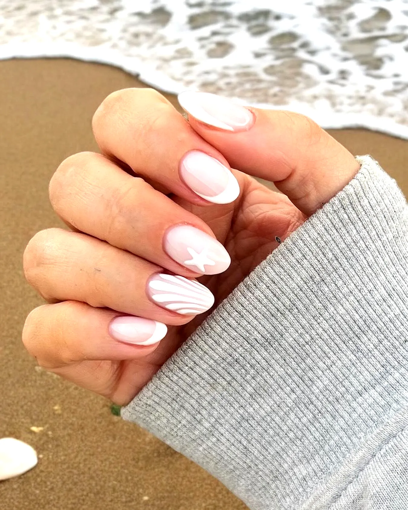 Cute Oval Beach Nails with Soft Pink and White French Tips and Wavy Patterns