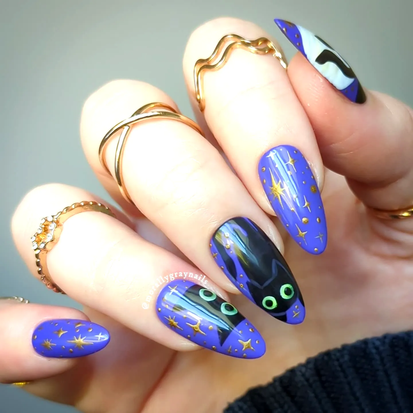 Cute pointed black cat nails with a purple background whimsical golden stars and a spooky moon