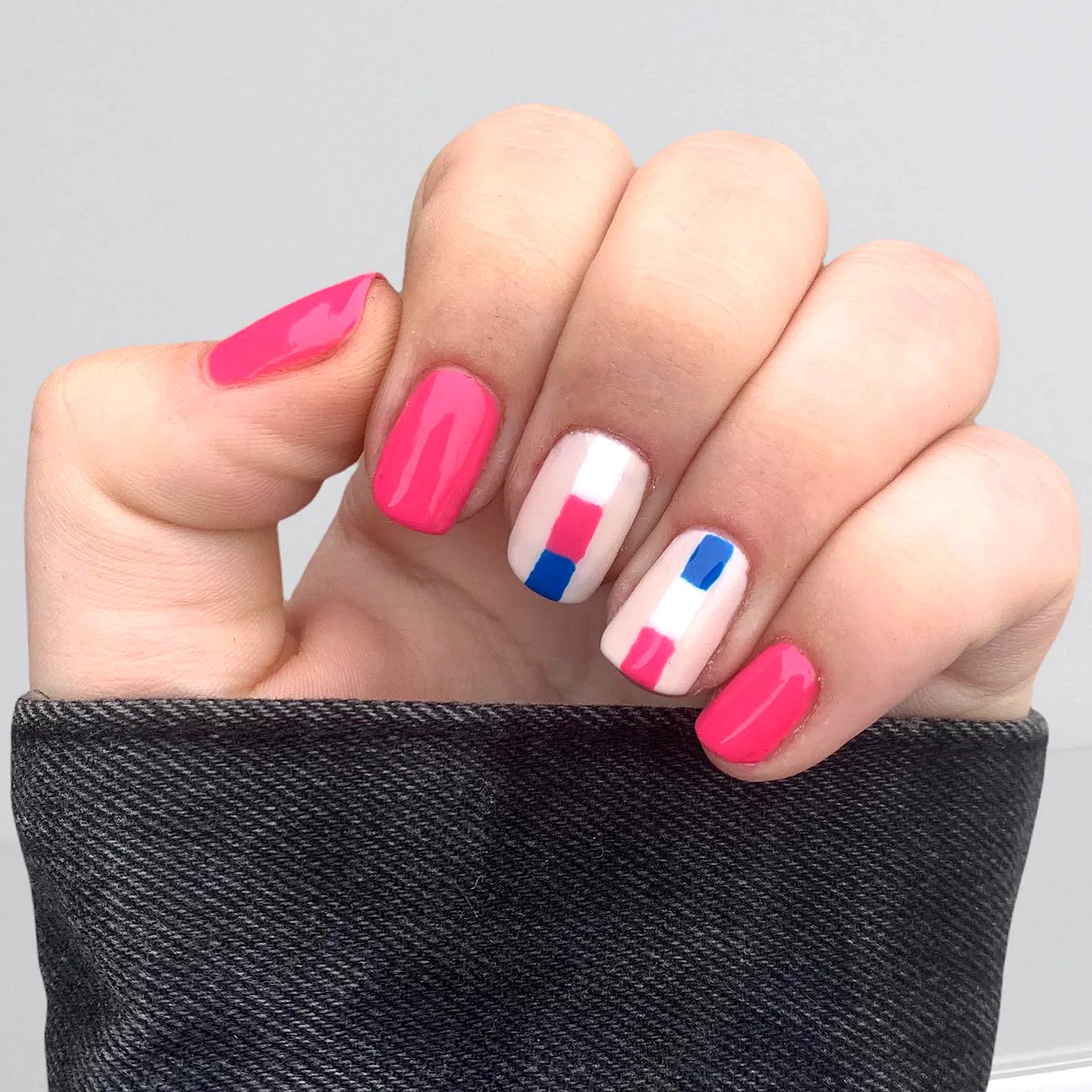 Cute rounded color block nails with bright pink white and blue geometric patterns