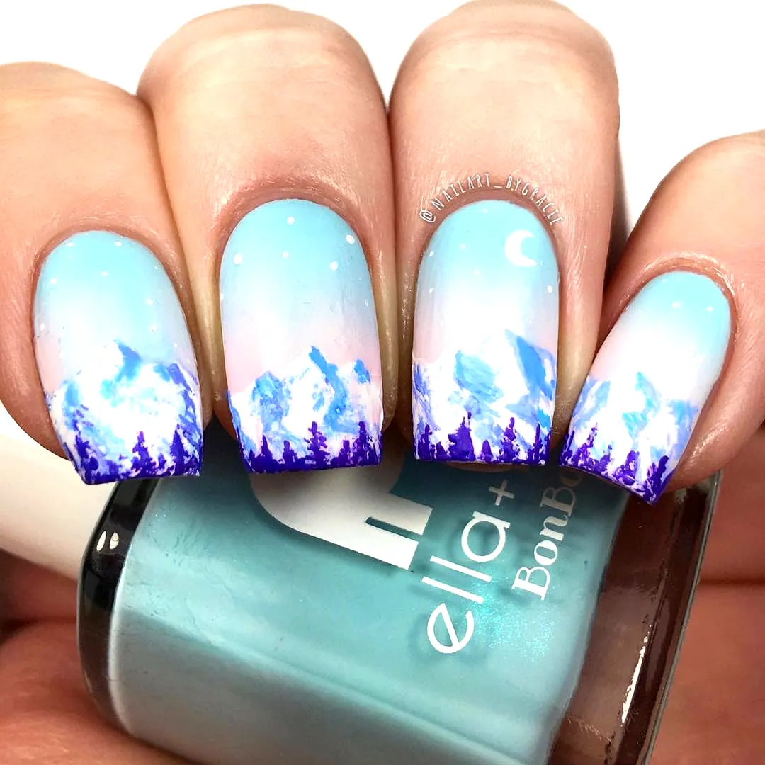 Cute rounded mountain nails with a sky-blue gradient and whimsical purple snowy peaks and crescent moon