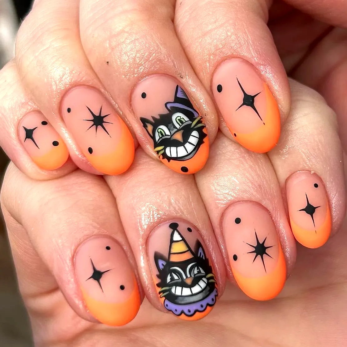 Cute short rounded black cat nails with vibrant orange ombre and whimsical designs