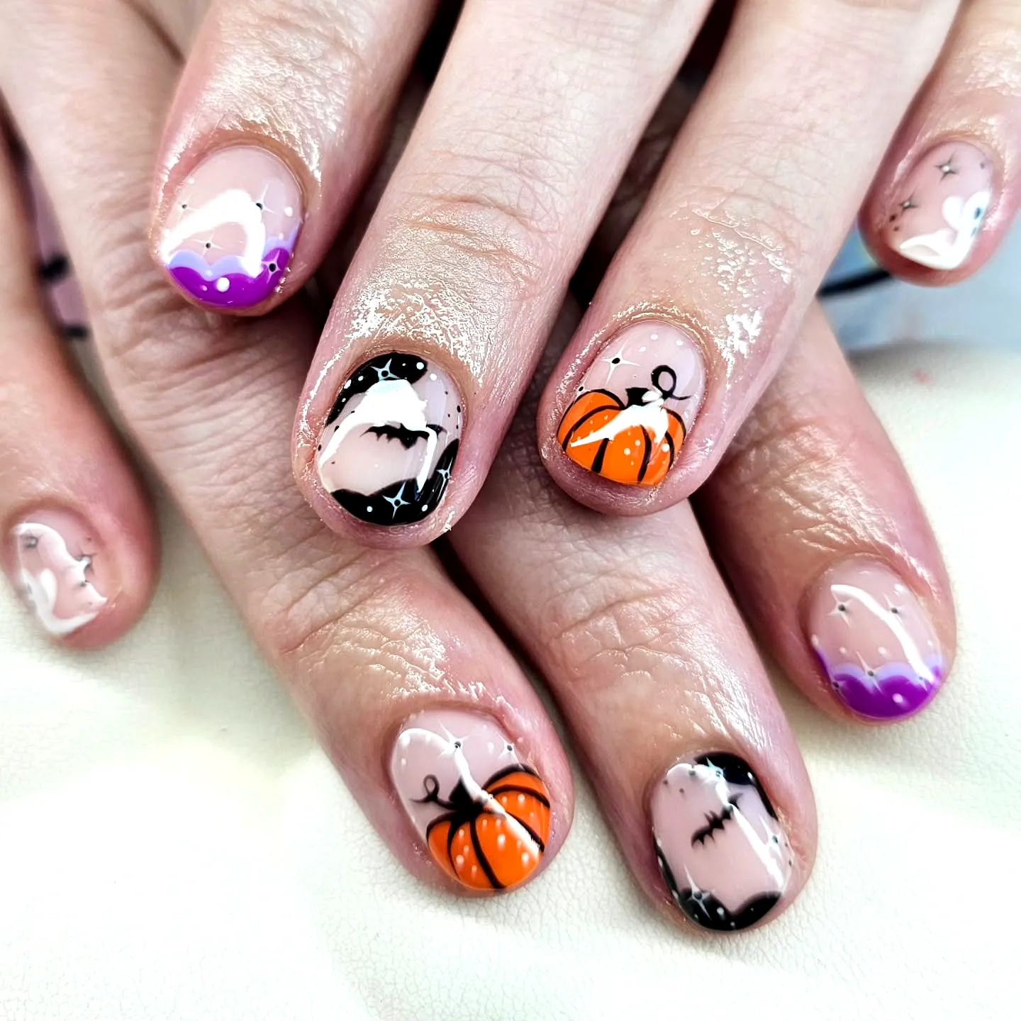 Cute Short Rounded Pumpkin Nails with Ghost Illustrations in Orange Black and Purple Glossy Finish