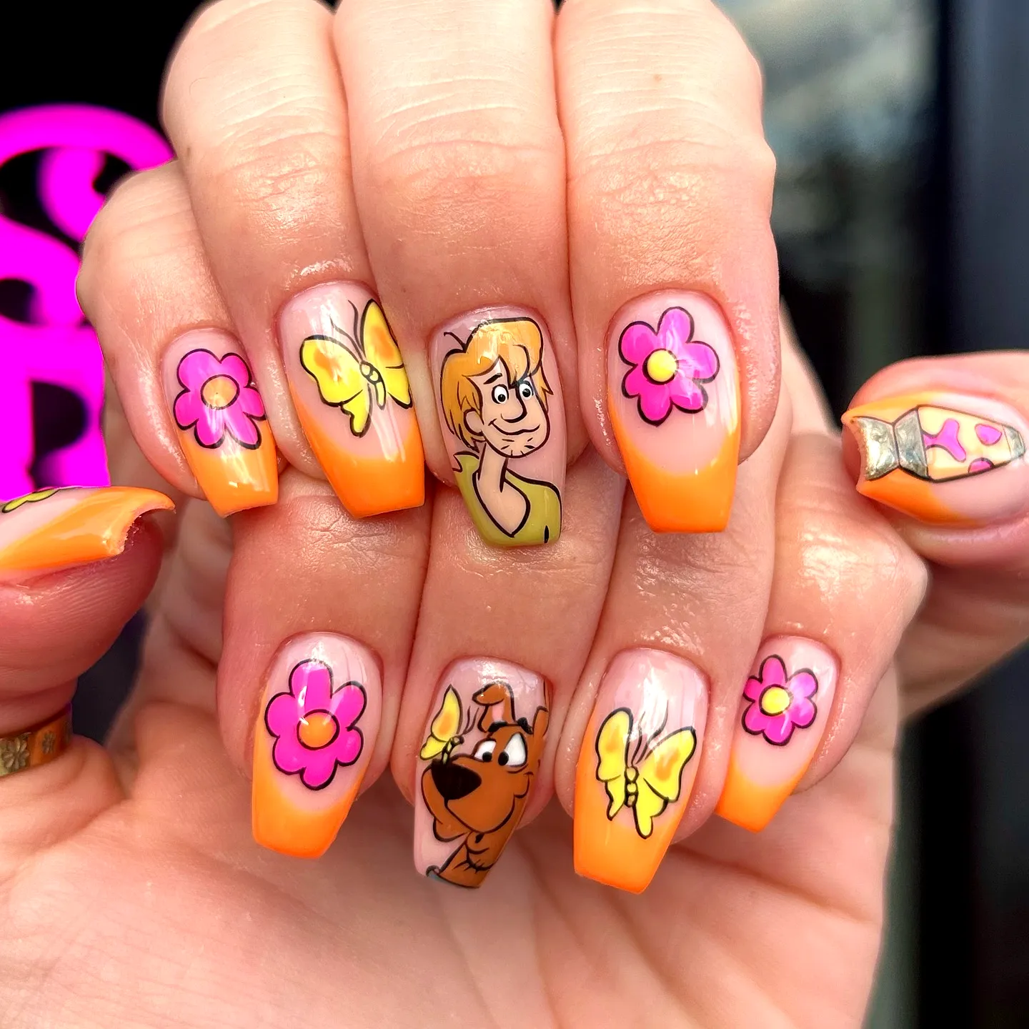 Cute square cartoon nails with vibrant orange and peach gradient and playful floral elements