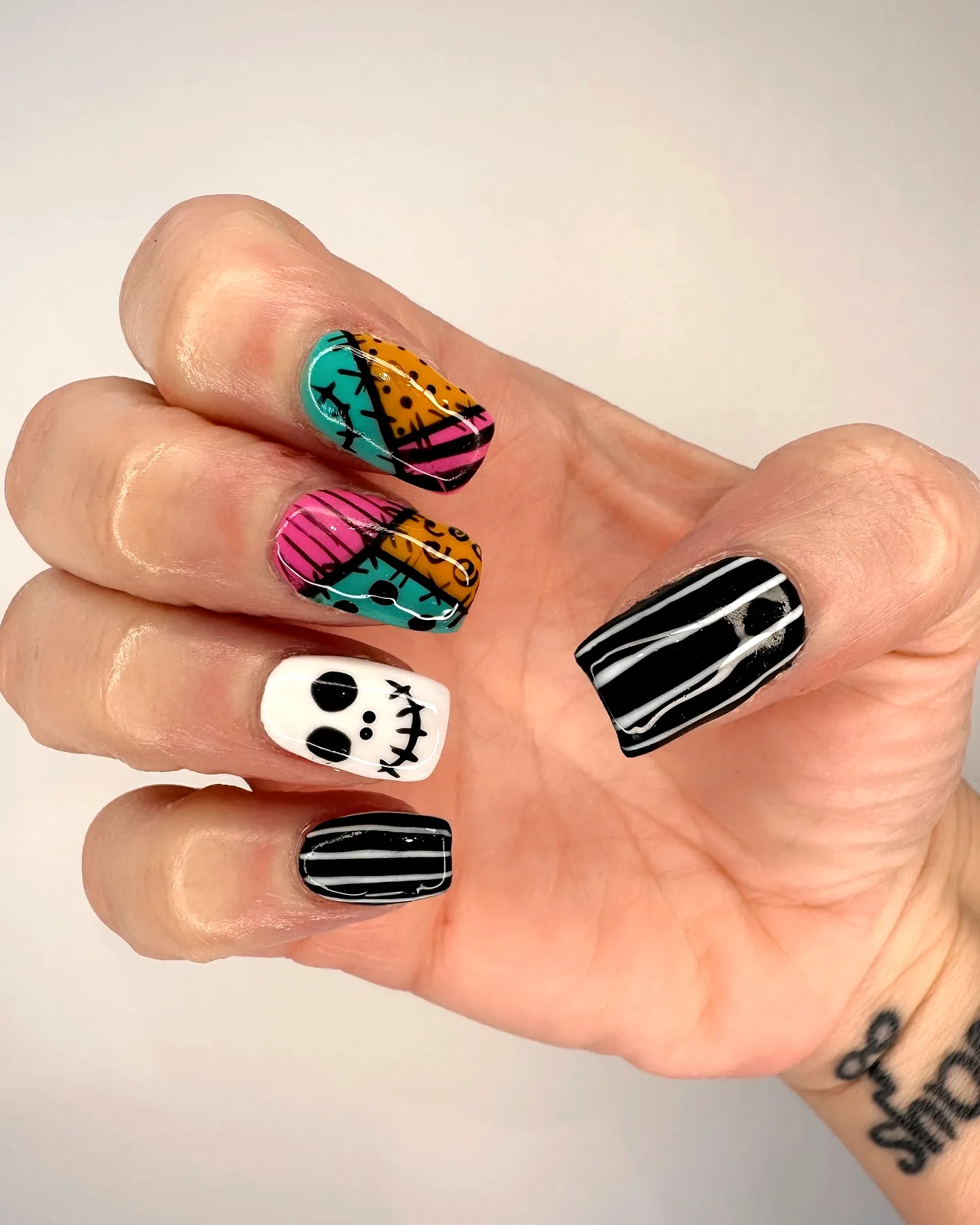 Cute square Nightmare before christmas nails with colorful stripes and playful skull designs