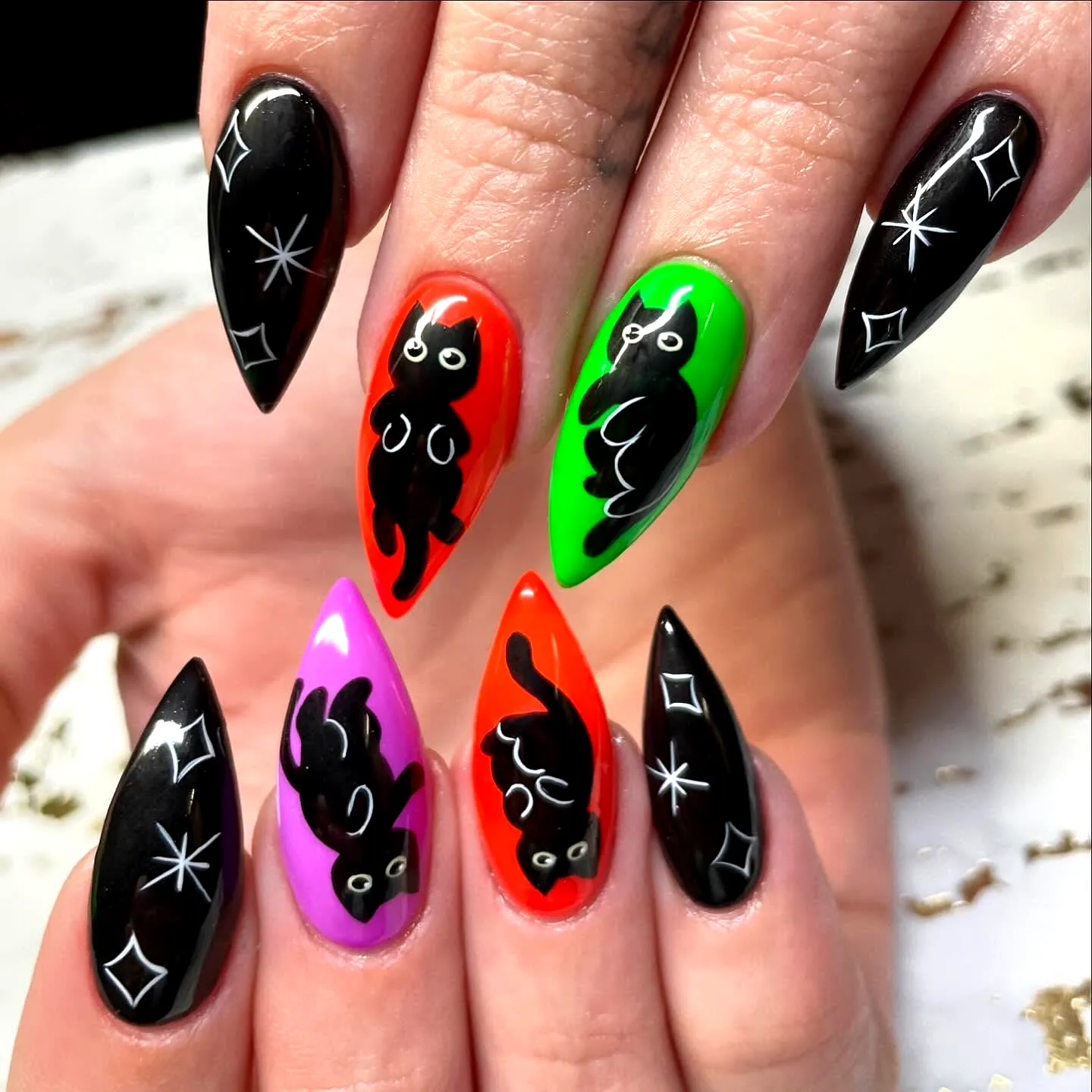 Cute Stiletto Black Cat Nails with Vibrant Neon Colors and Whimsical Cartoon Designs